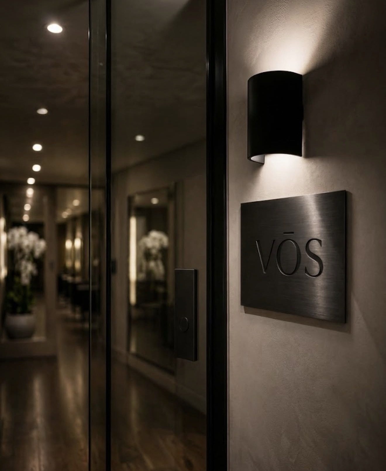 VŌS exterior signage with warm sconce lighting